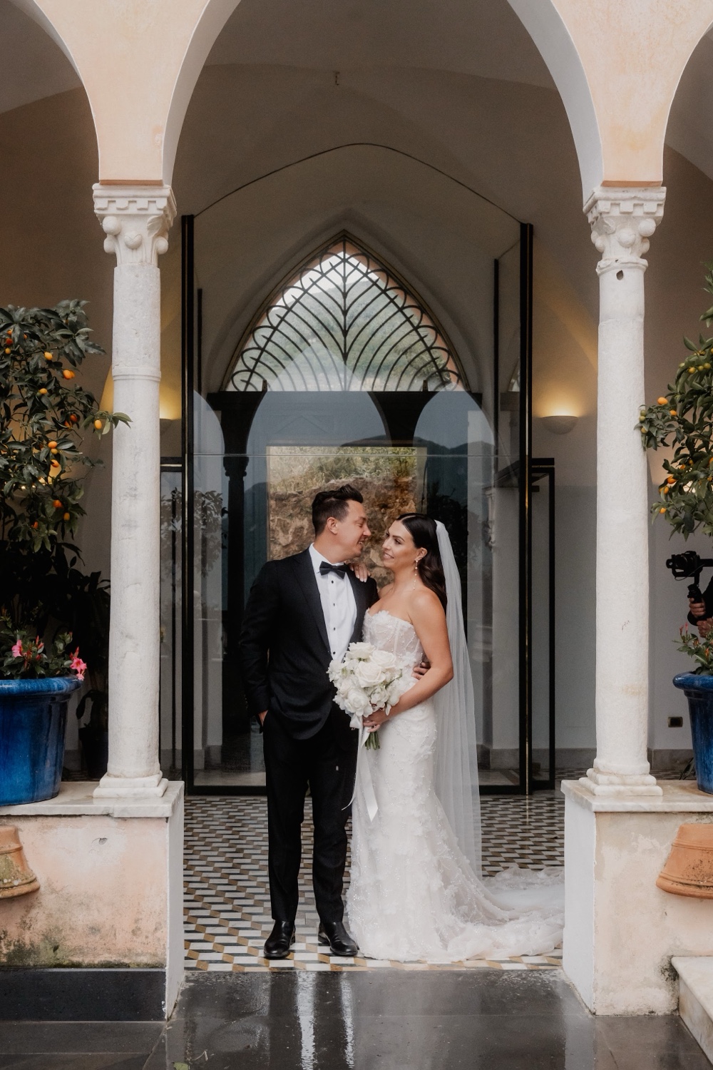 A couple embracing in an arched doorway with columns at Palazzo Avino in Ravello