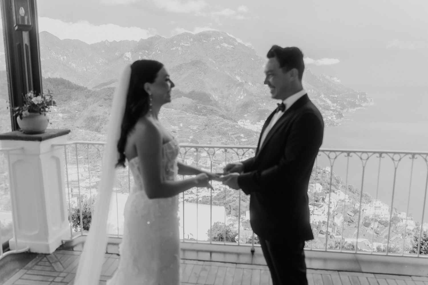 A couple exchanging vows on the terrace of Palazzo Avino in Ravello, with the coast behind them