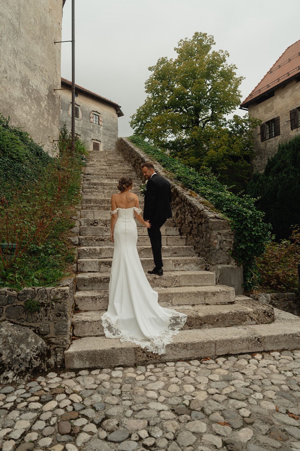 A couple walking up the old stone stairs of Bled Castle, Slovenia