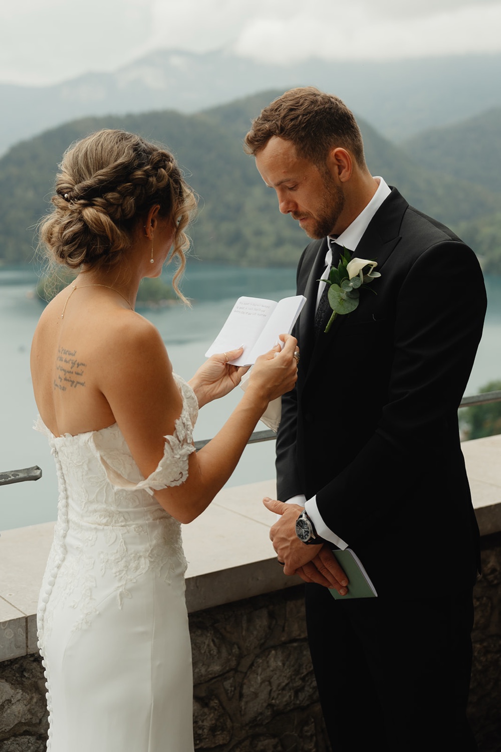 A bride and groom reading their vows on the terrace of Bled Castle, Slovenia
