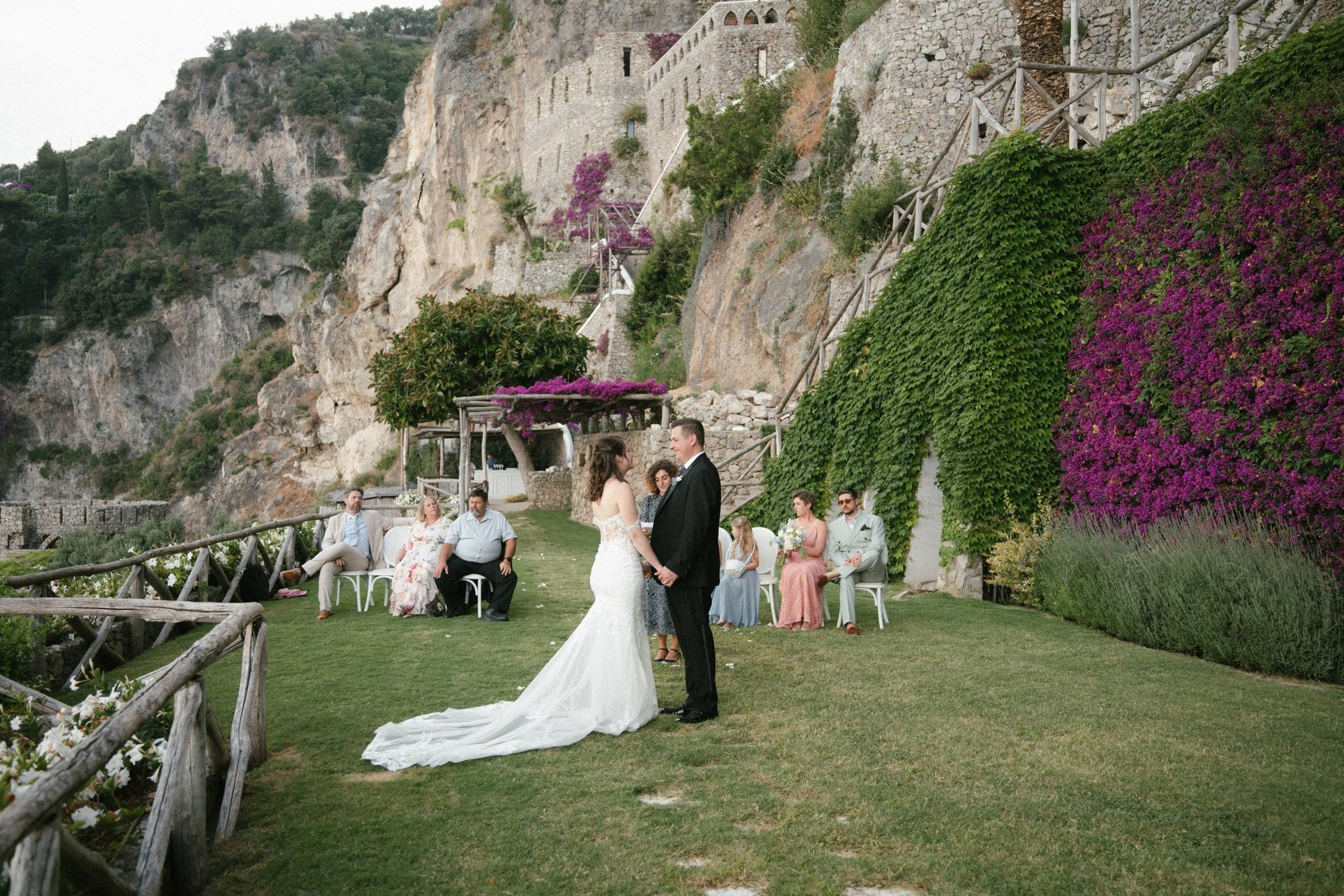 A symbolic ceremony in the Seaview Garden at Borgo Santandrea, with bougainvillea climbing the cliff behind