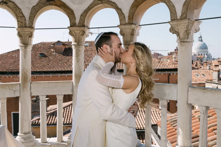 A kiss on the belvedere above the rooftops of Venice