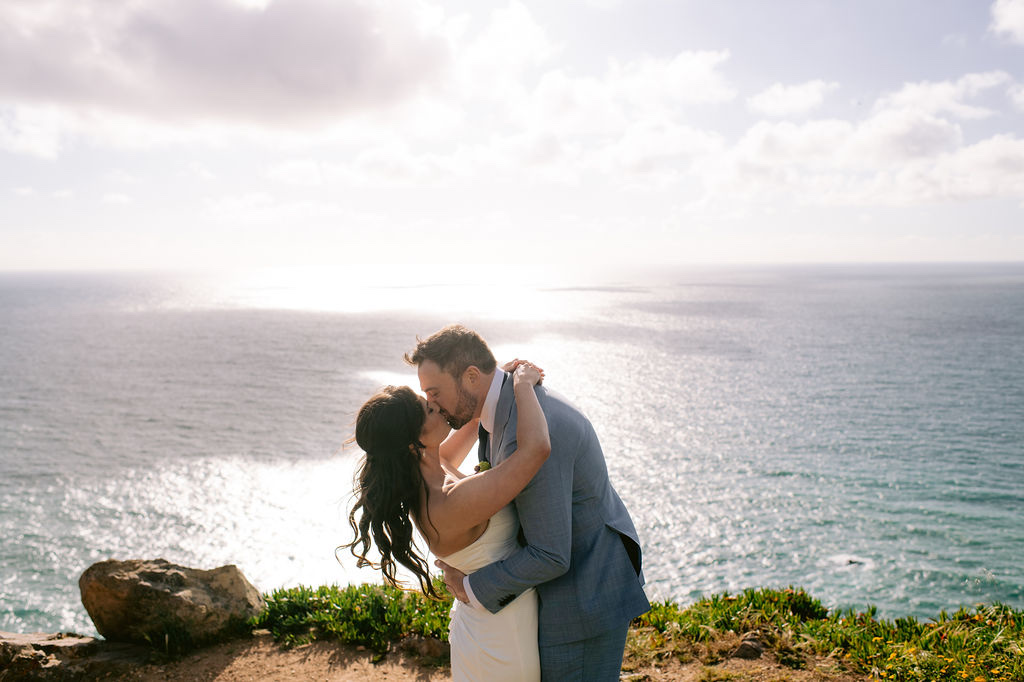 A couple kissing on the cliff edge at Cabo da Roca in Sintra, Portugal, in soft evening light