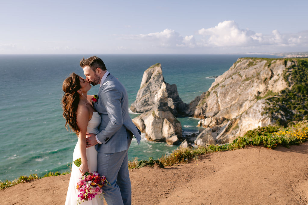 A couple kissing in front of the sea stacks at Cabo da Roca in Sintra, Portugal