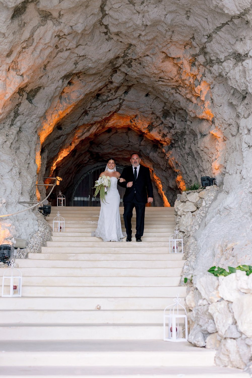 A bride arriving through the rock passage to the beach