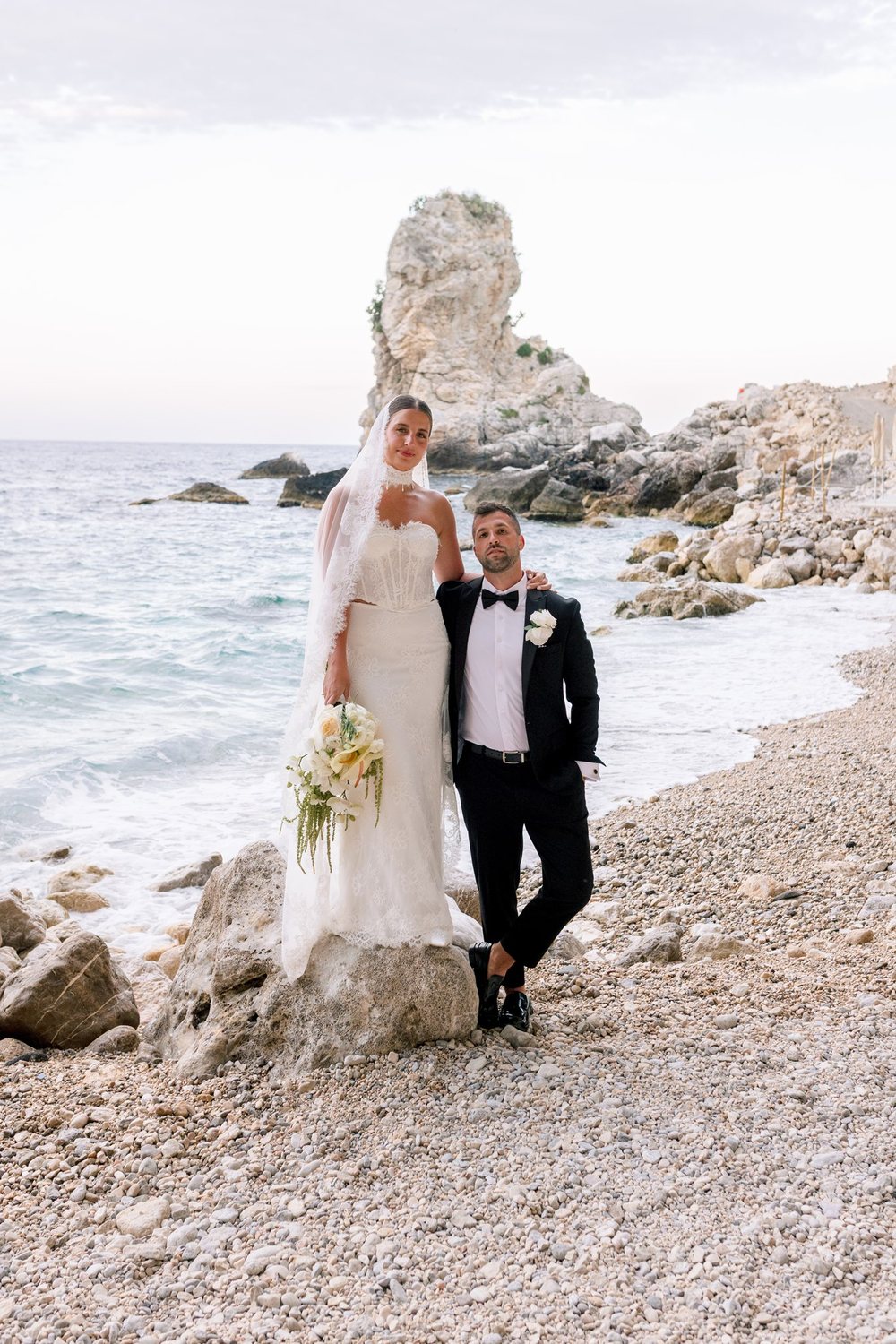 A couple on the beach, with a sea stack behind