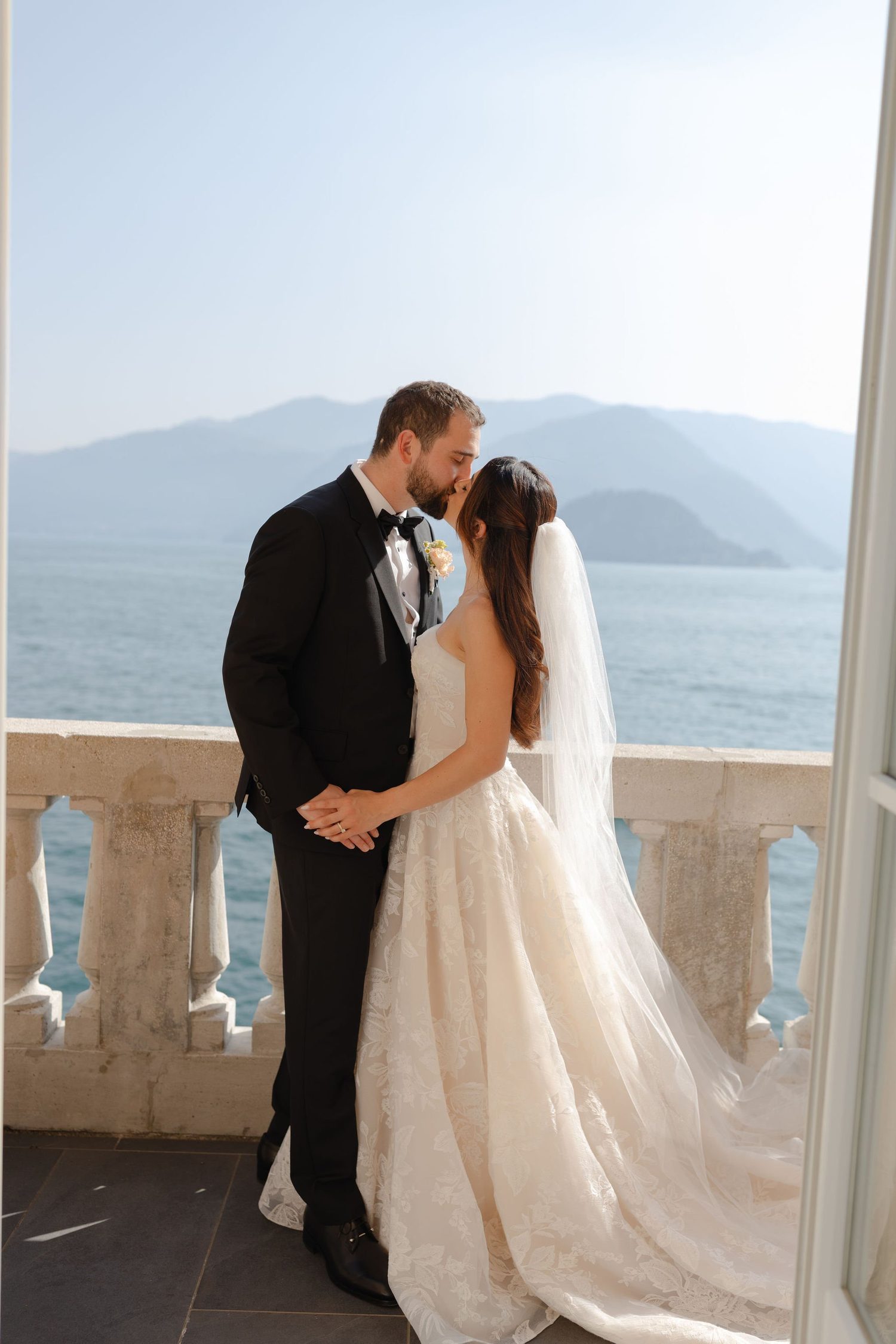 A kiss at the stone balustrade above Lake Como at Villa Cipressi