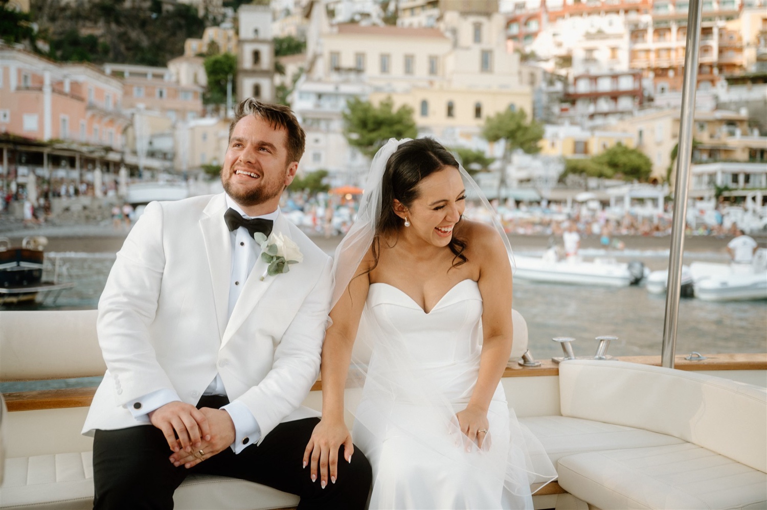 A couple sitting together on a boat off the coast of Positano