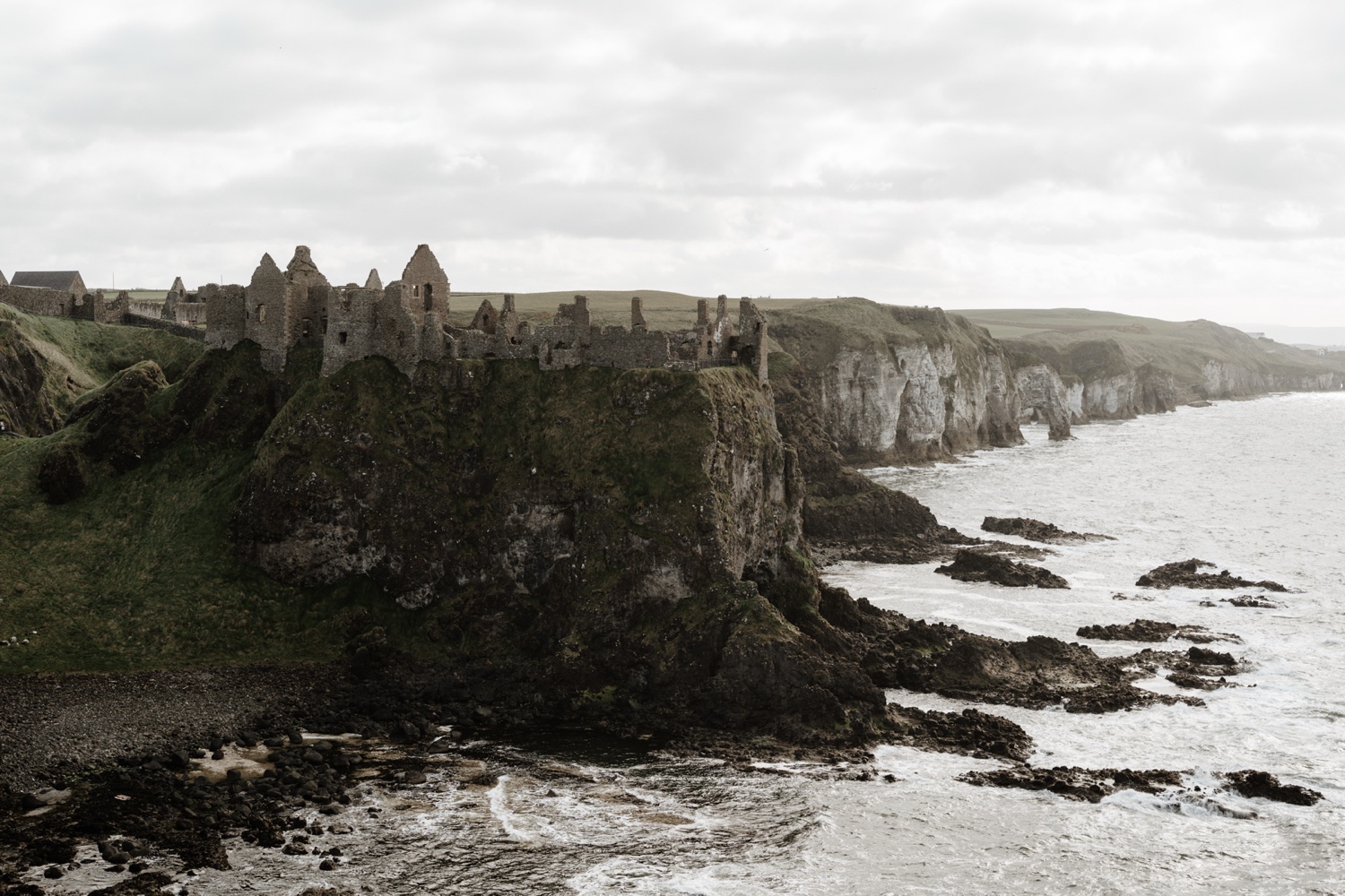 The ruins of Dunluce Castle on a cliff above the sea on the north coast of Northern Ireland