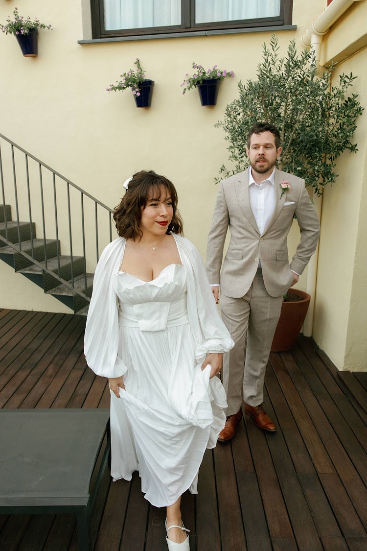 A bride in a white dress and groom on the staircase at EME Catedral Mercer in Seville, Spain