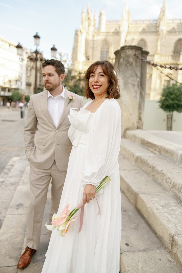 A bride and groom on the steps beside Seville Cathedral, a short walk from EME Catedral Mercer