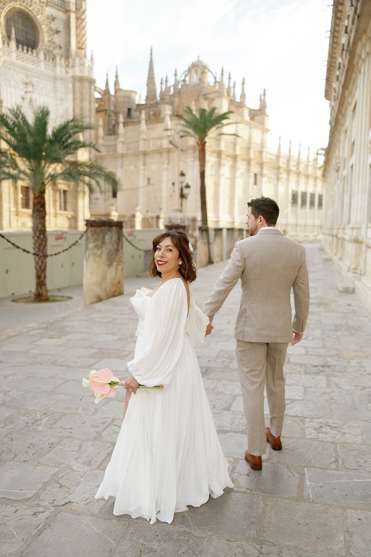 A couple walking along the street beside Seville Cathedral near EME Catedral Mercer in Seville