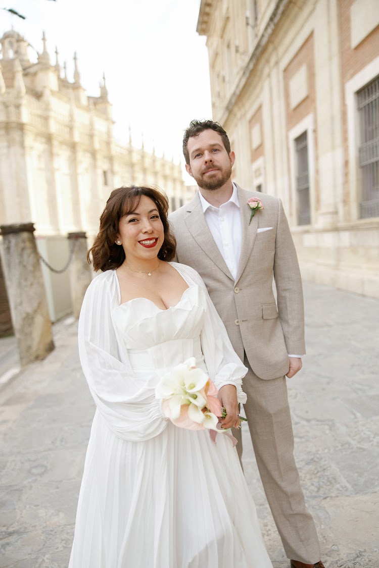 A smiling bride and groom in a Seville street near the Cathedral, close to EME Catedral Mercer