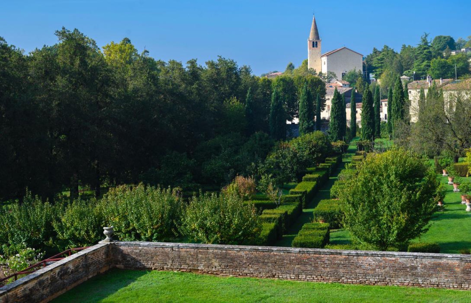 The terraced gardens of Villa Fracanzan Piovene with a church tower beyond, near Verona