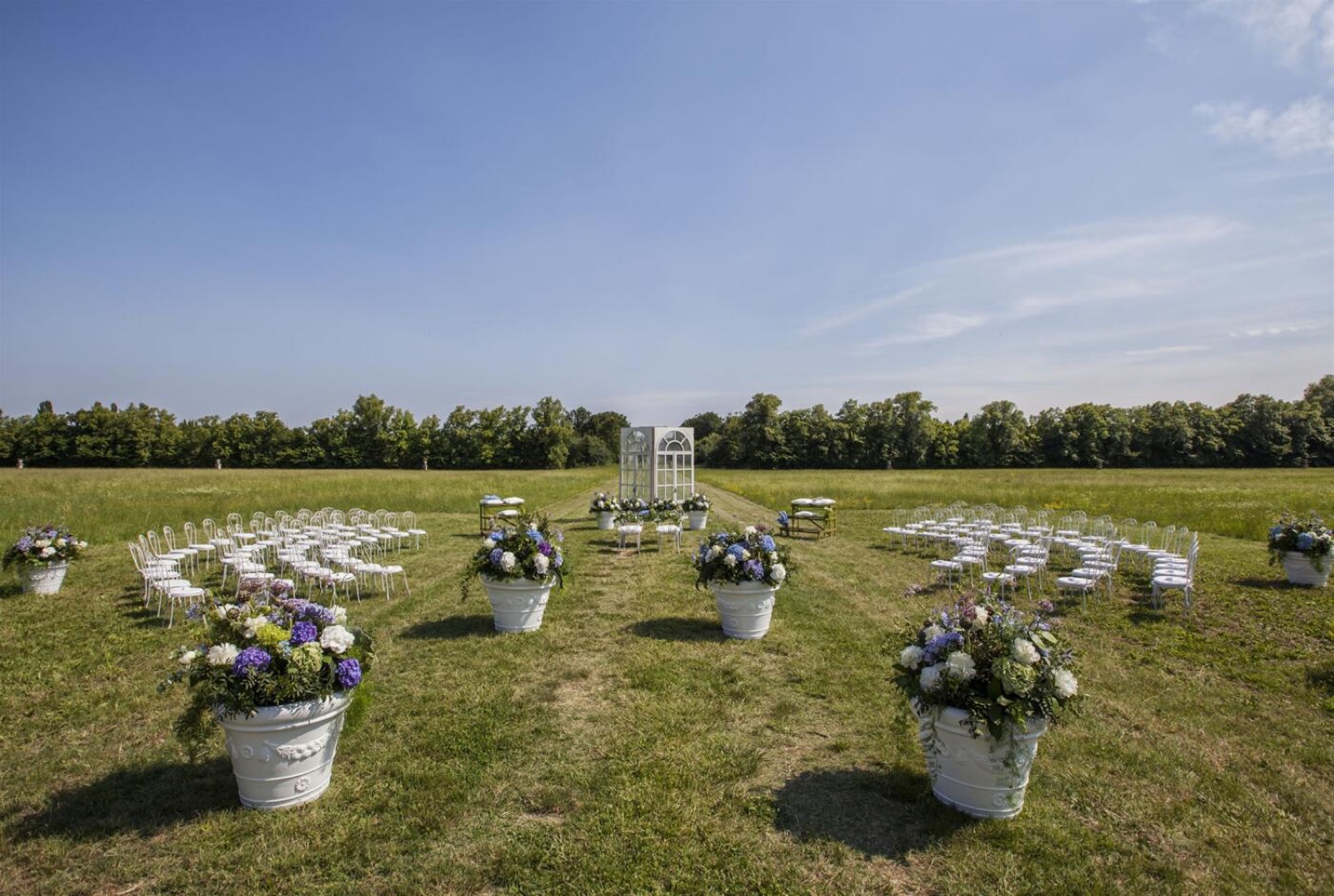 A circle of flower pots and chairs set out for a ceremony on the lawn at Villa Fracanzan Piovene near Verona