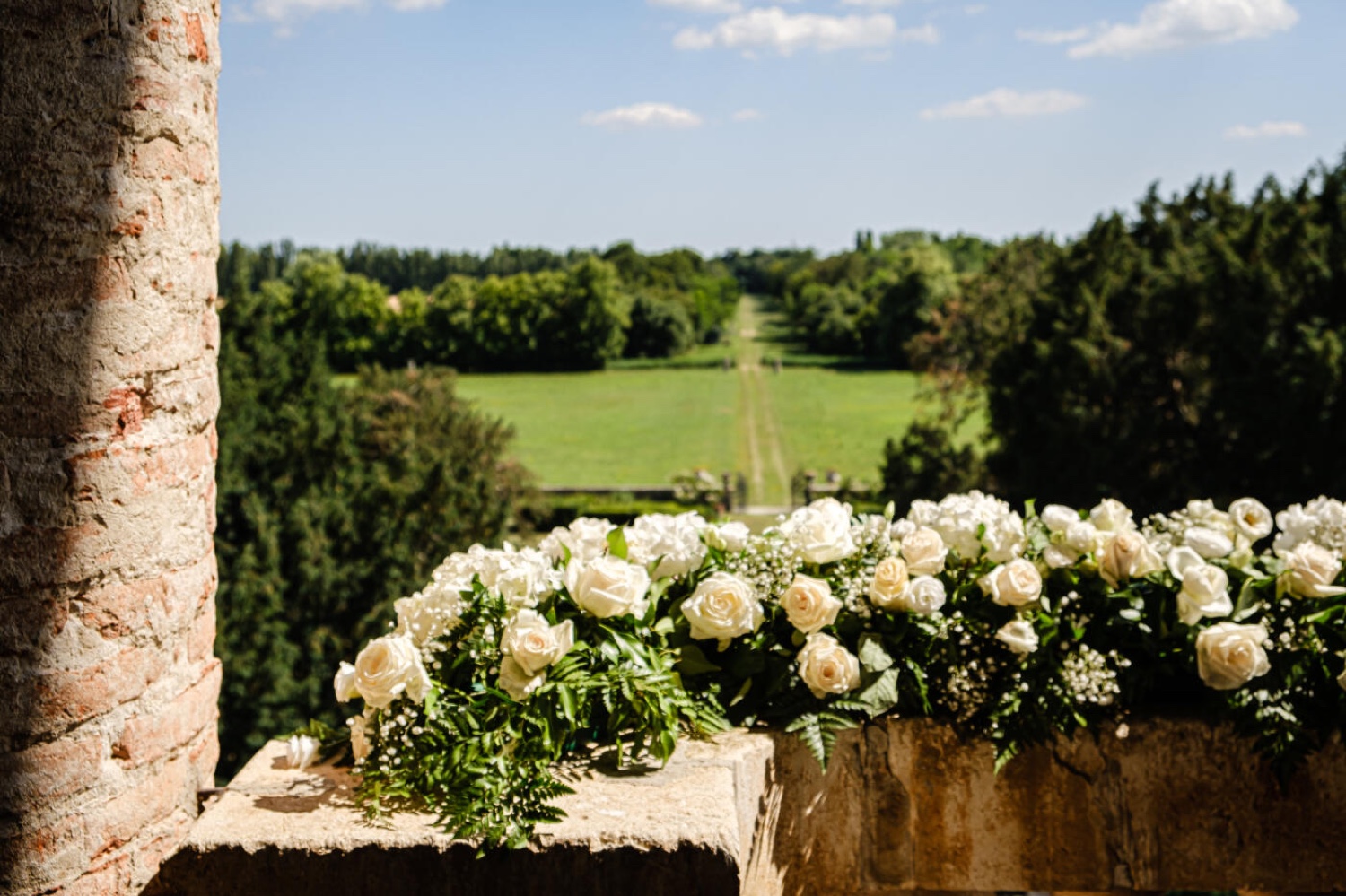 White flowers on a stone balustrade at Villa Fracanzan Piovene, with the gardens beyond, near Verona