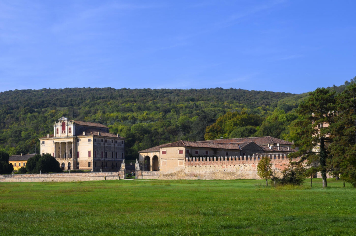 Villa Fracanzan Piovene seen across the green lawn, with the wooded hills of the Veneto behind