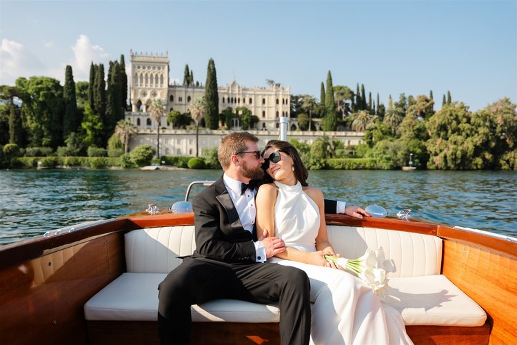 A couple on a private boat in front of Isola del Garda