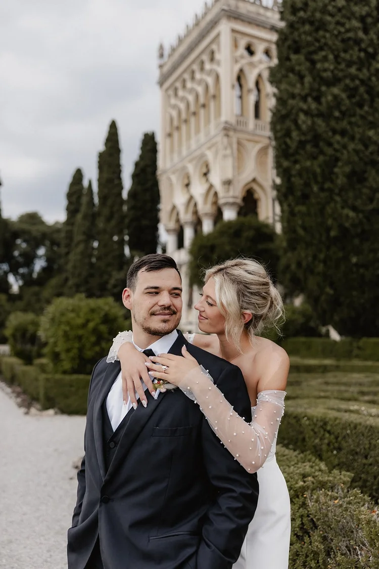 A couple embracing in the Italian gardens of Isola del Garda