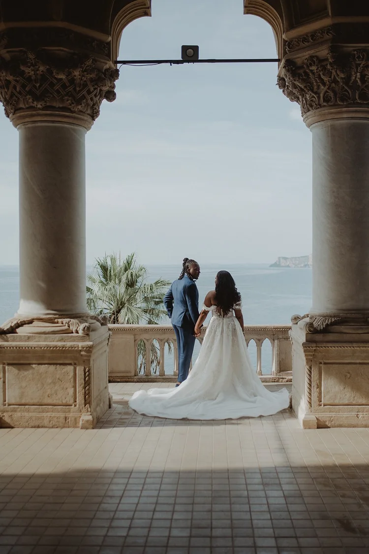 A couple in the loggia of the villa, looking out over the lake