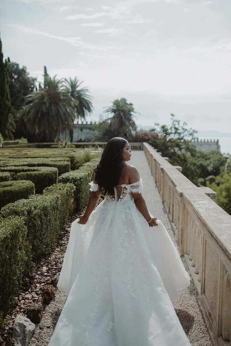 A bride walking through the gardens of Isola del Garda