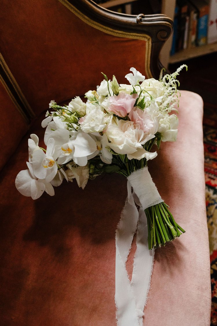 A bridal bouquet of white and blush flowers held by the bride in Sicily