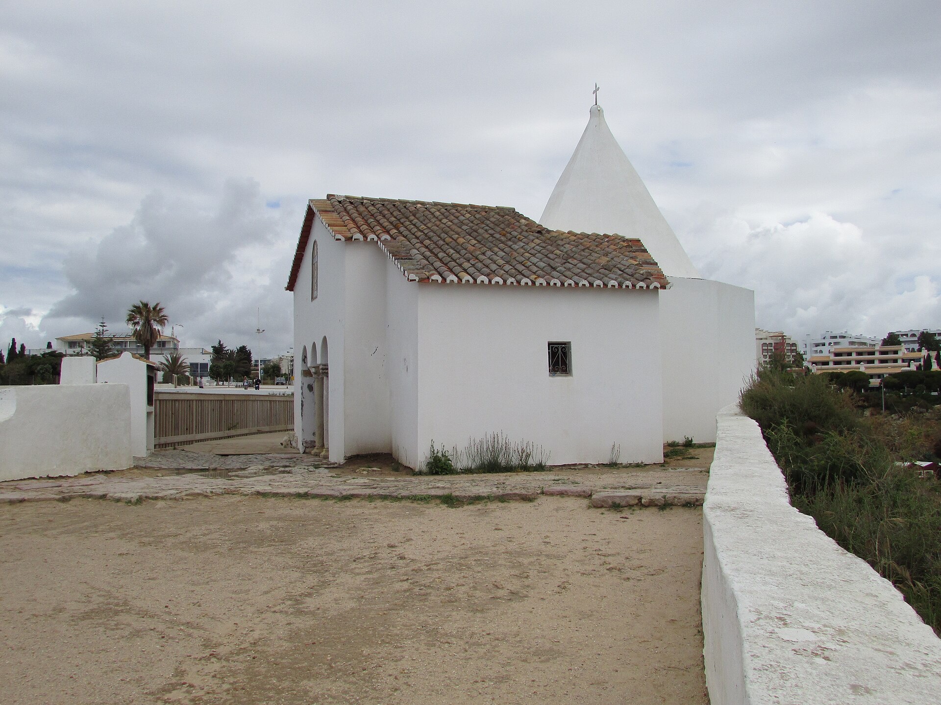 The white chapel of Lady of the Rock with its pointed steeple and little arched porch, on the cliff-top terrace in Porches, Algarve