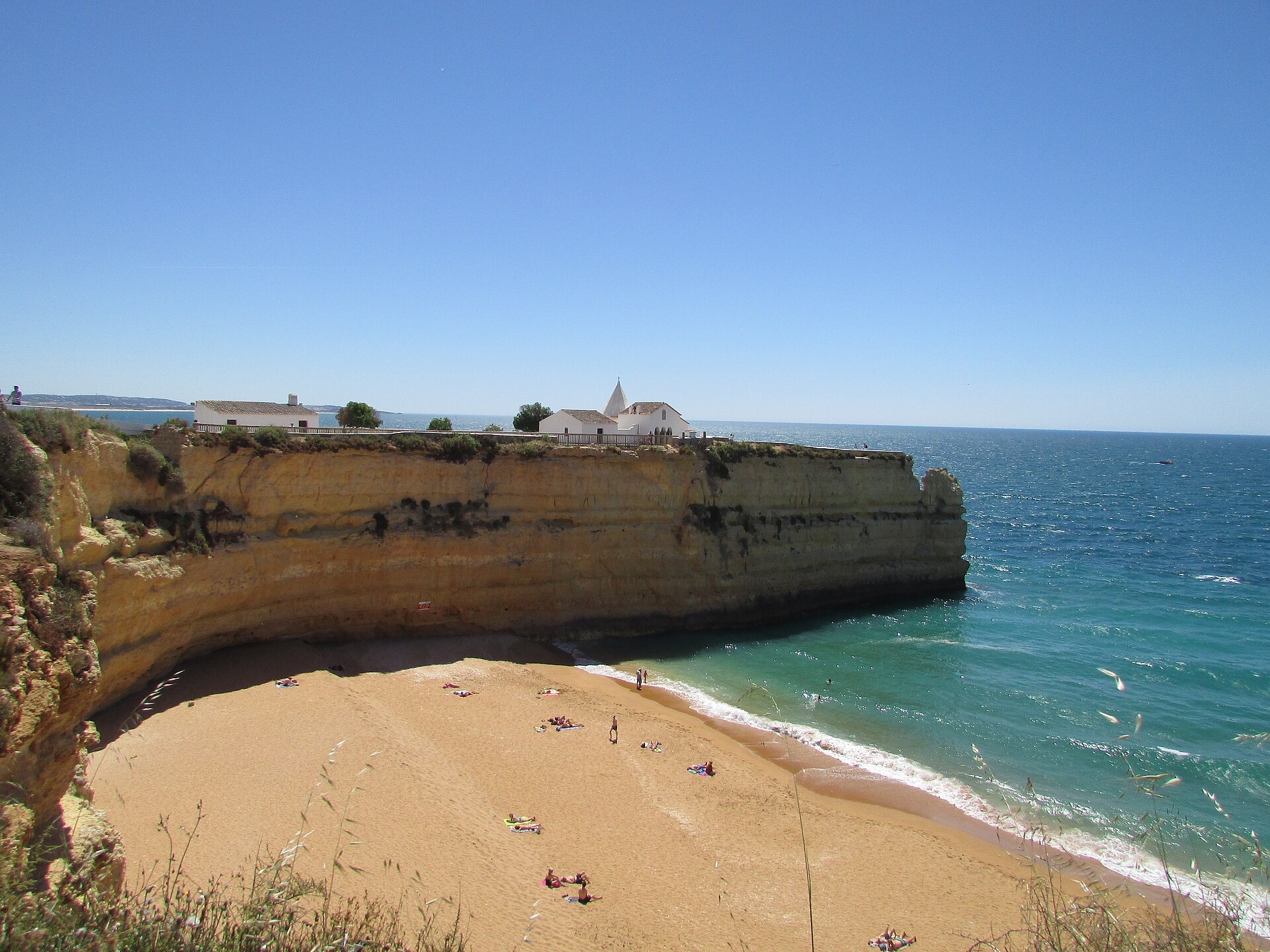 The cliff-top headland of Lady of the Rock above the beach and the sea in Porches, Algarve, Portugal