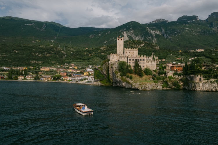 The castle of Malcesine and the village seen from the water of Lake Garda