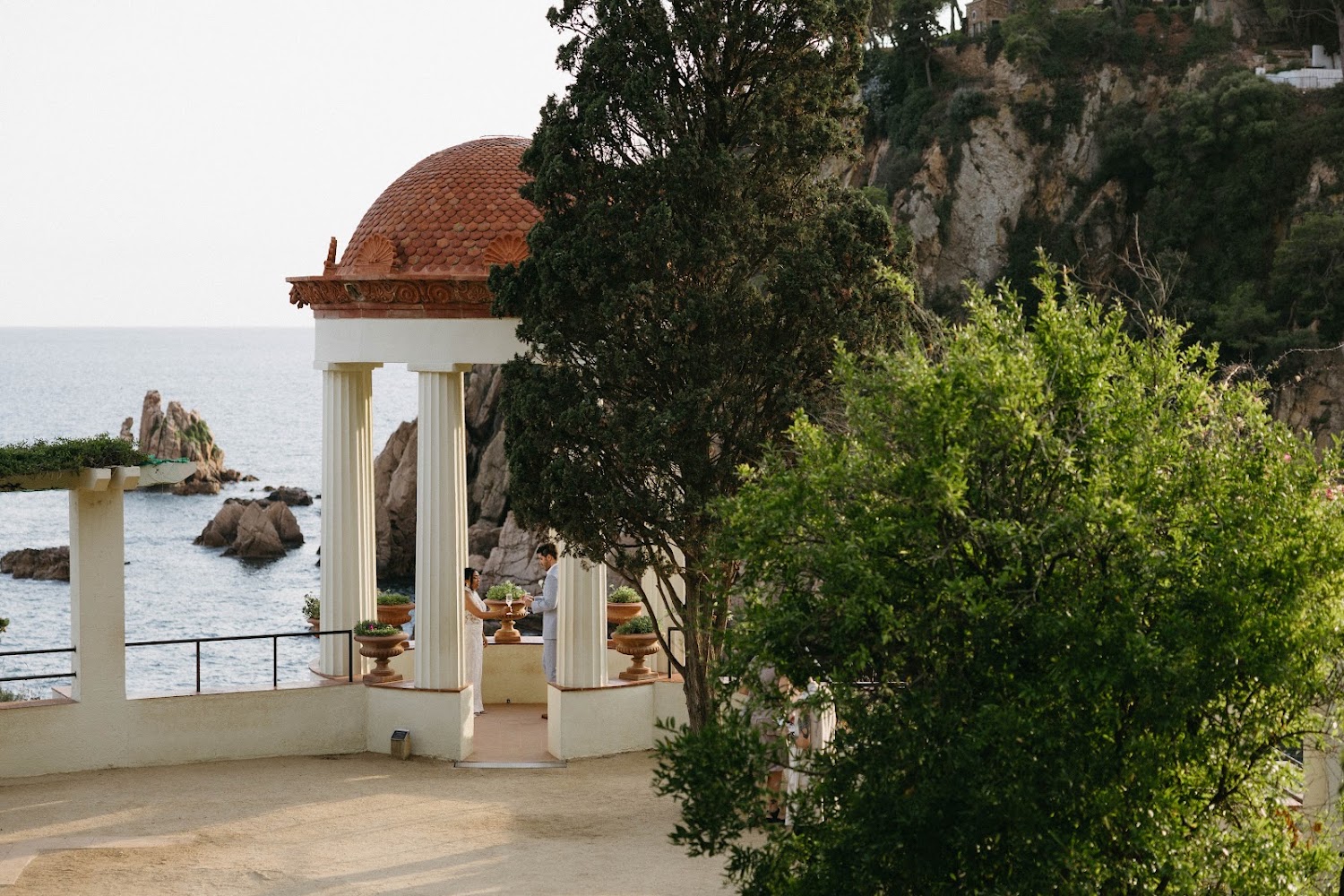 A couple exchanging vows inside the Linnaeus Temple on the cliff edge of Marimurtra Botanic Gardens above the Mediterranean on the Costa Brava
