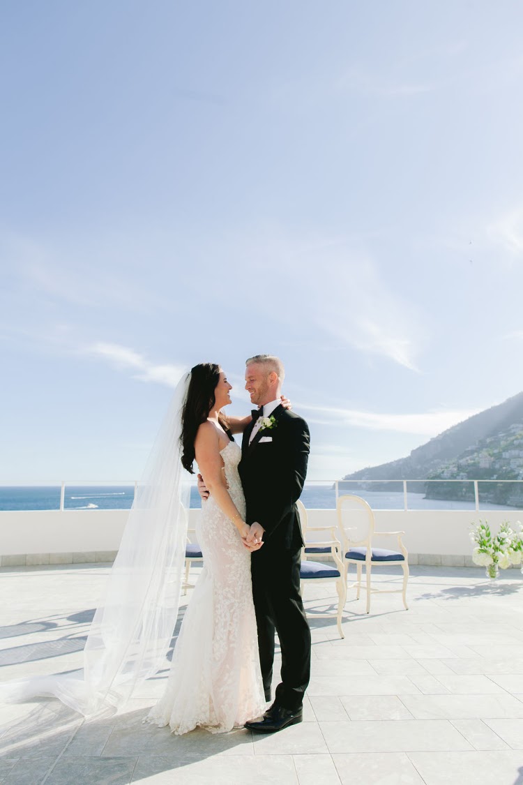 Elopement couple standing together on the white rooftop terrace of Hotel Marina Riviera on the Amalfi Coast above the Amalfi sea