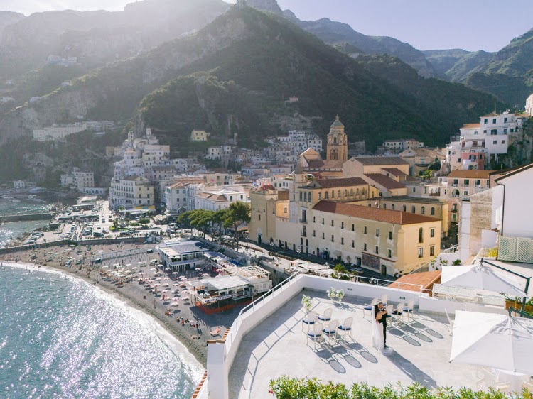 Rooftop terrace of Hotel Marina Riviera on the Amalfi Coast seen from above with the couple, Amalfi beach and cathedral