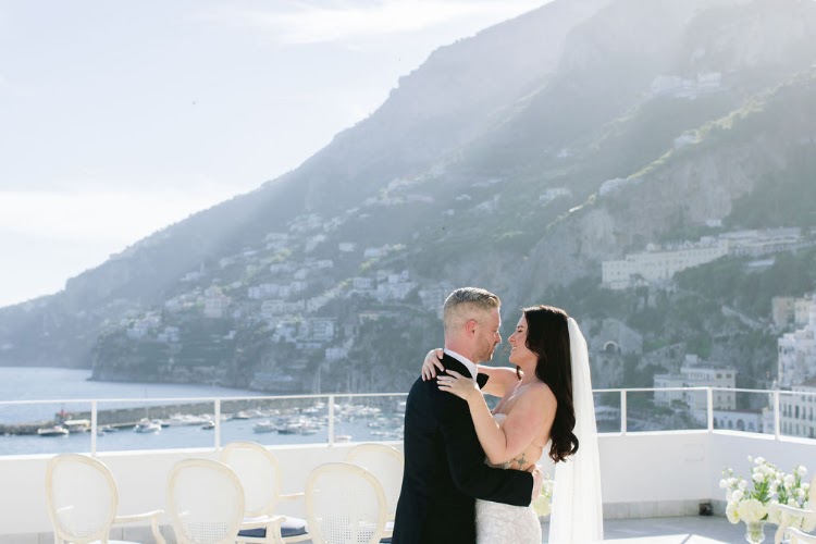 Couple embracing on the rooftop ceremony terrace of Hotel Marina Riviera on the Amalfi Coast with Amalfi Coast mountains