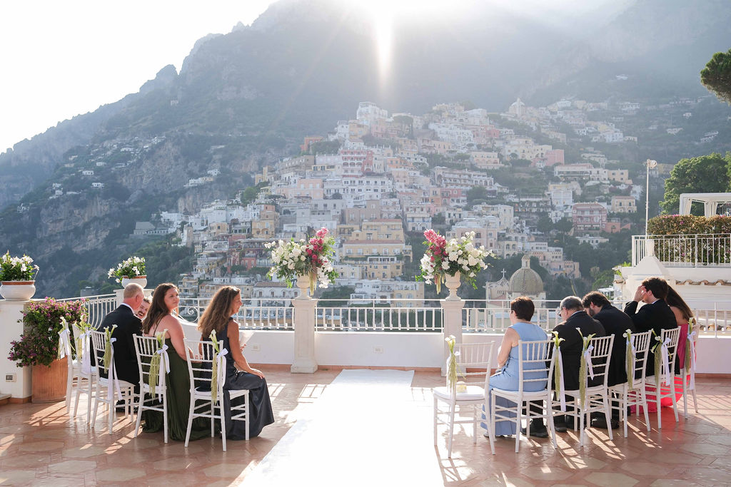 Guests seated on the Marincanto rooftop terrace for a ceremony, with Positano behind