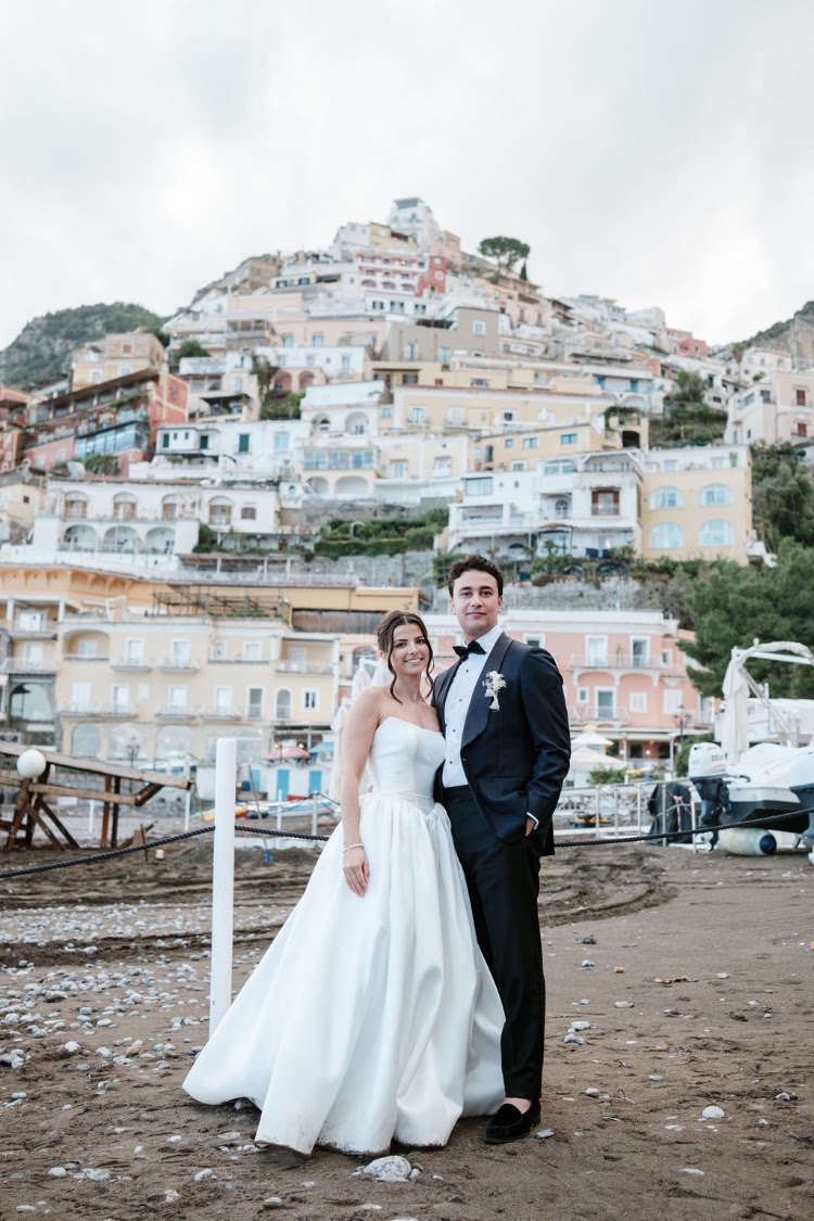 A couple on the beach, with Positano behind