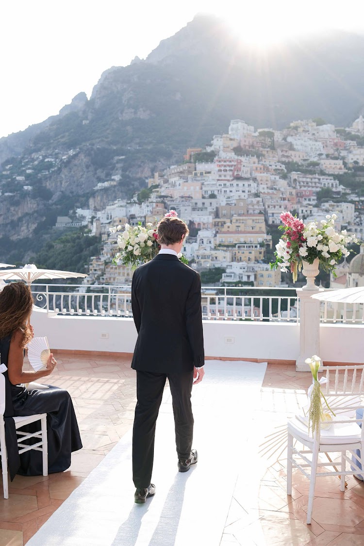 A groom waiting at the altar on the Marincanto terrace, with Positano behind