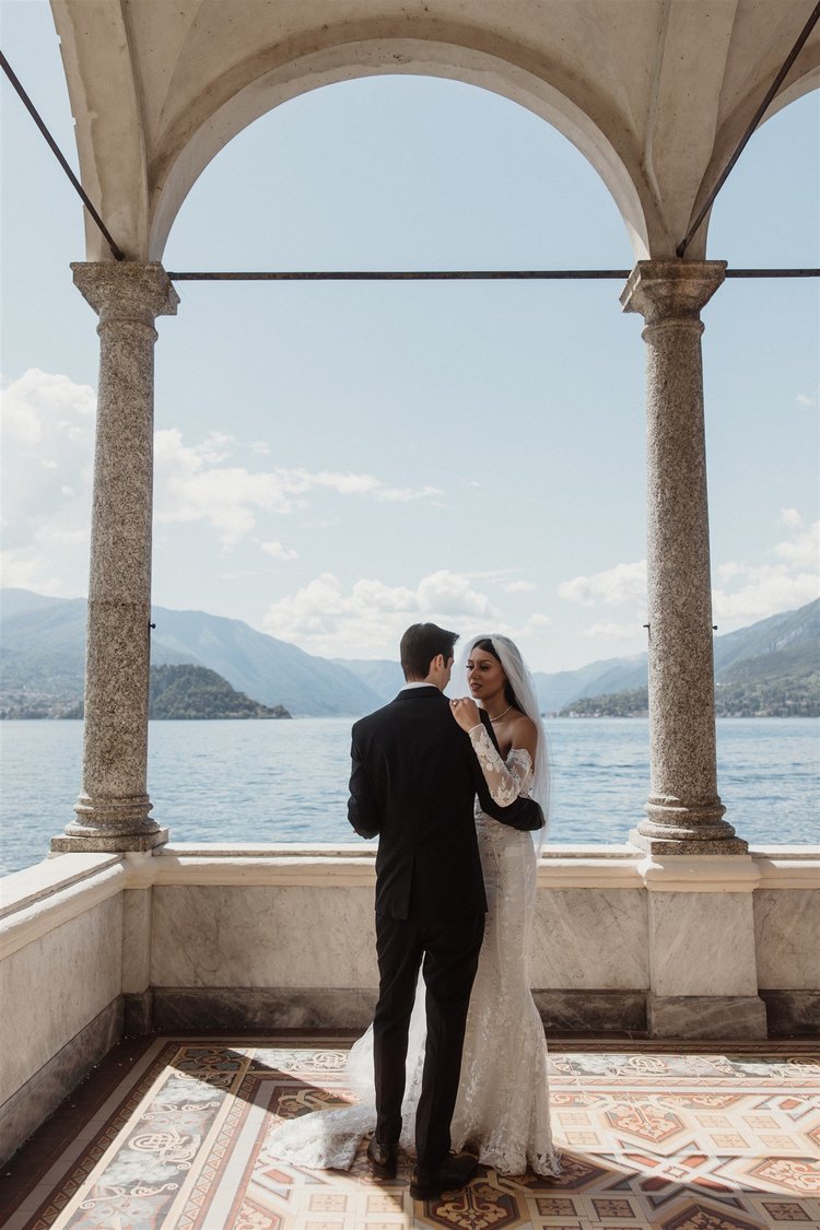 A couple under the arches of the balcony at Villa Monastero, above the lake
