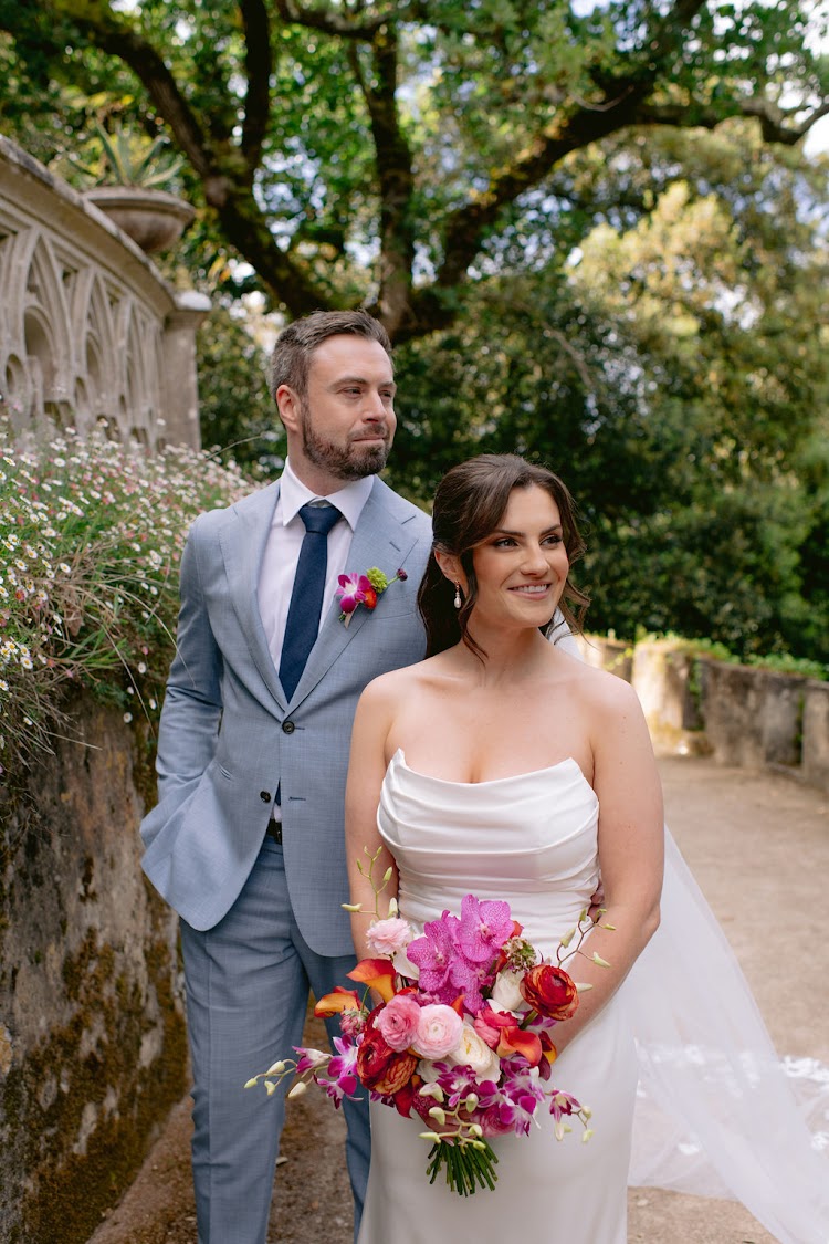 A couple posing on the garden path under oak trees at Monserrate Palace in Sintra, Portugal