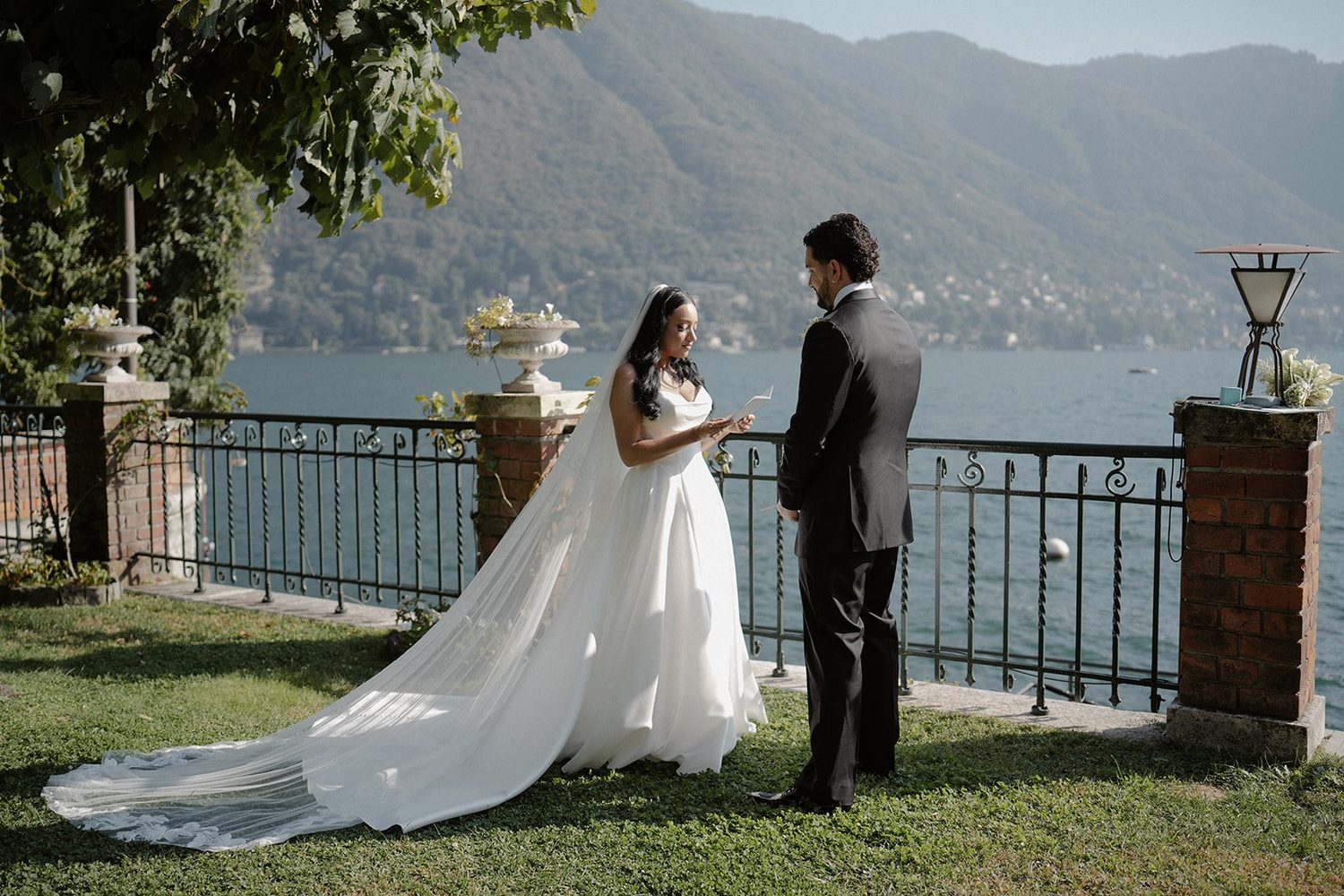 A couple exchanging vows on the lakeside lawn at Villa Noseda