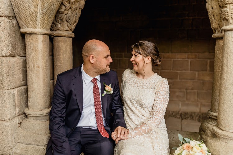 A couple sitting together between stone columns in the monastery cloister at Poble Espanyol in Barcelona