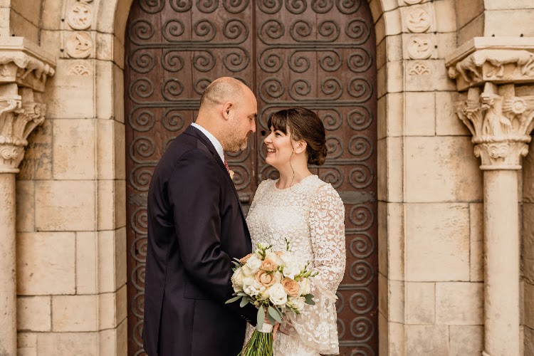 A couple smiling at each other in front of the monastery doorway at Poble Espanyol in Barcelona
