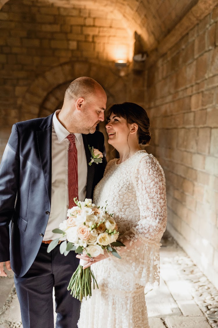 A couple sharing a close moment in the stone cloister gallery at Poble Espanyol in Barcelona