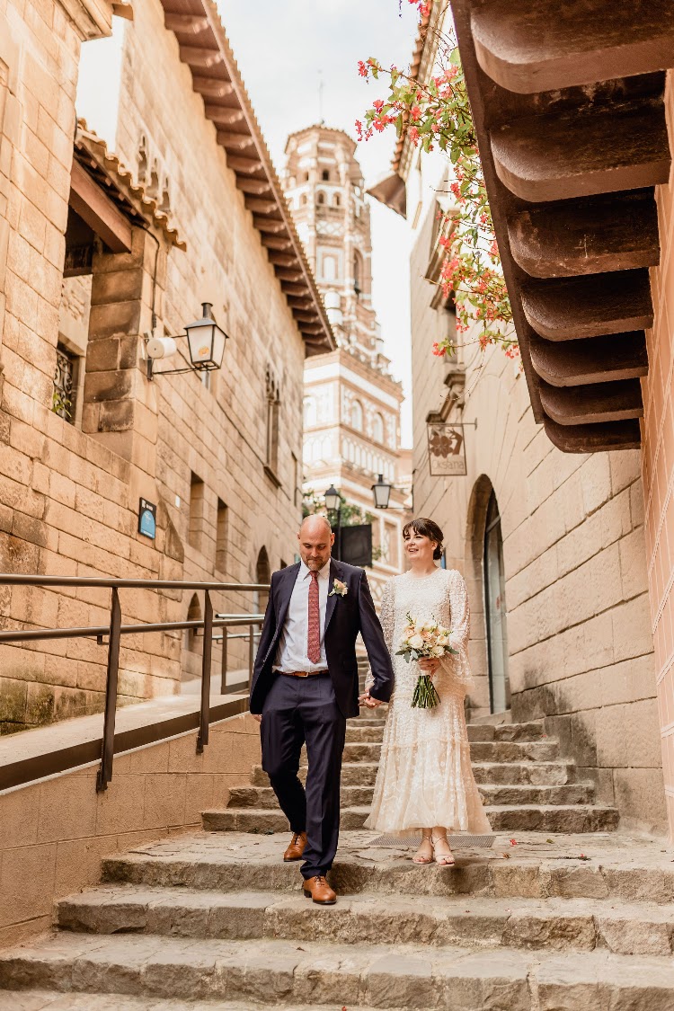 A couple walking down a narrow cobbled staircase in the Spanish village at Poble Espanyol in Barcelona