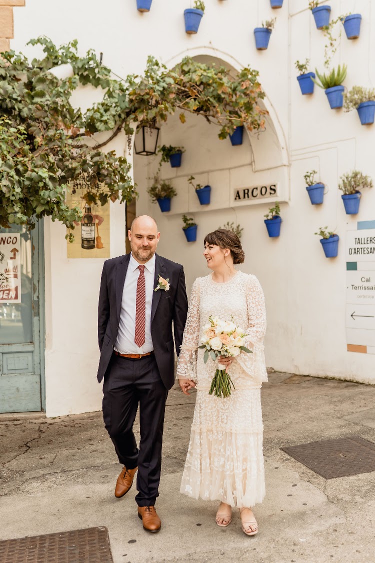 A couple strolling through a whitewashed Andalusian-style lane at Poble Espanyol in Barcelona