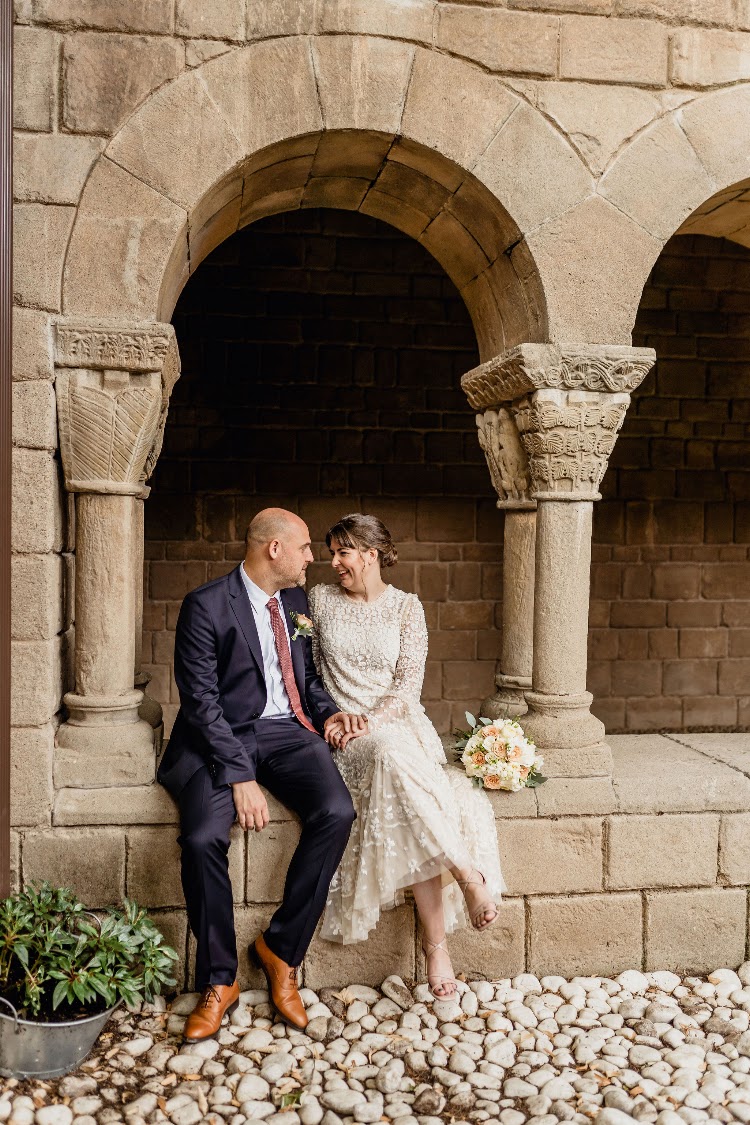 A couple seated under the stone arches of the cloister at Poble Espanyol in Barcelona