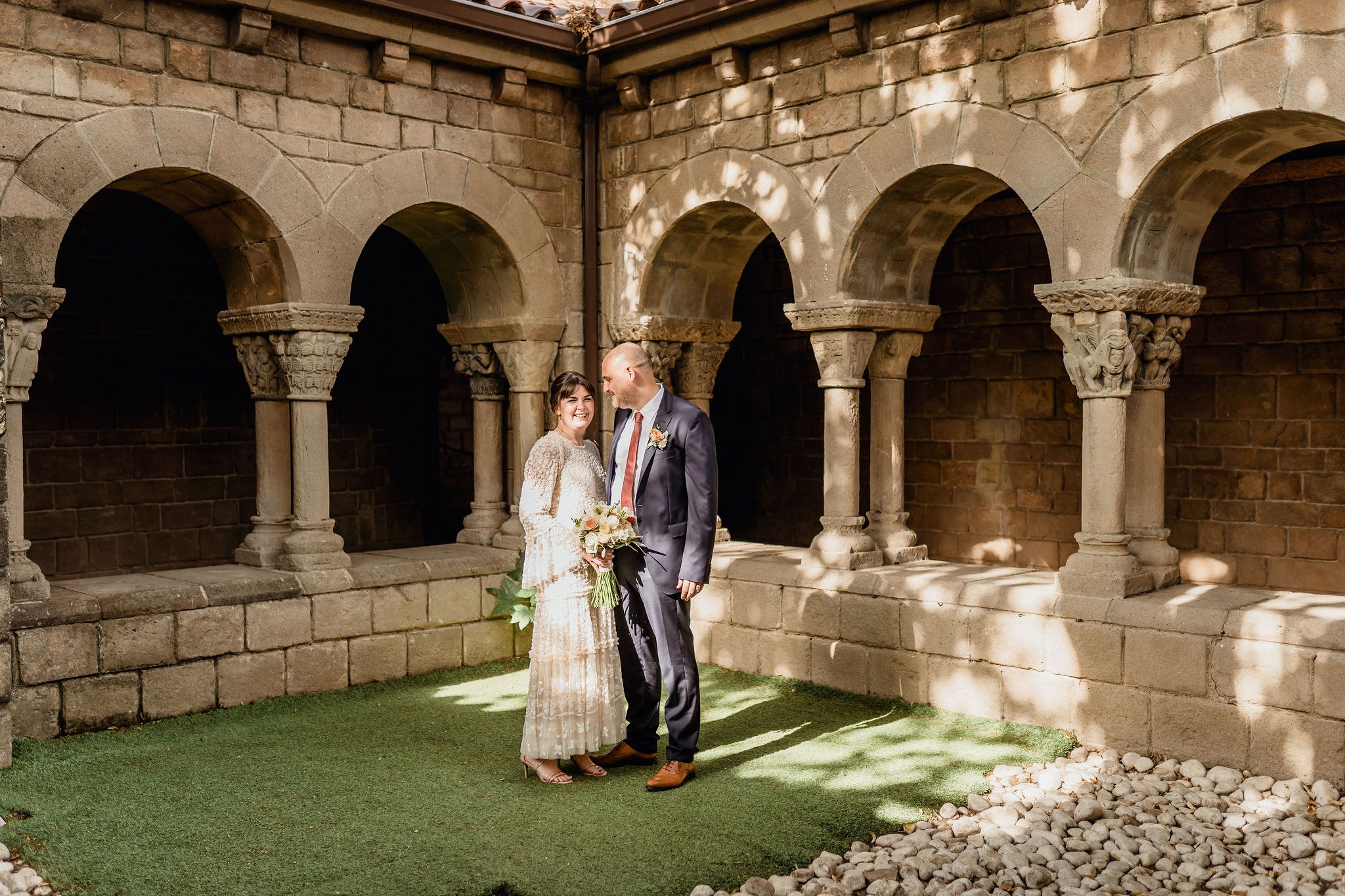 A couple standing together in the Romanesque stone cloister of the monastery at Poble Espanyol in Barcelona