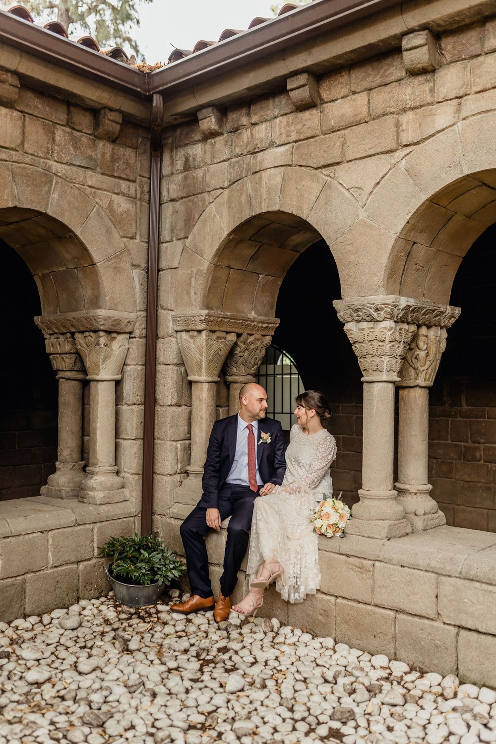 A couple sitting together in the stone cloister of the monastery at Poble Espanyol in Barcelona