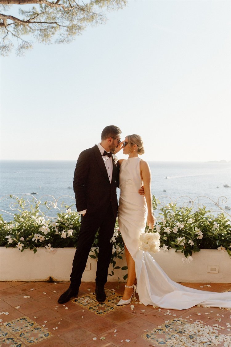 A couple on a terrace above the sea at golden hour