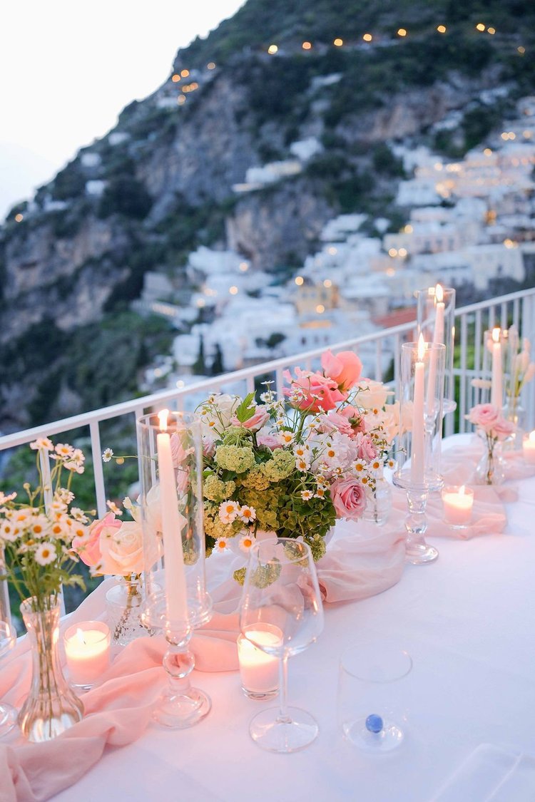 A candlelit table set on a terrace above Positano