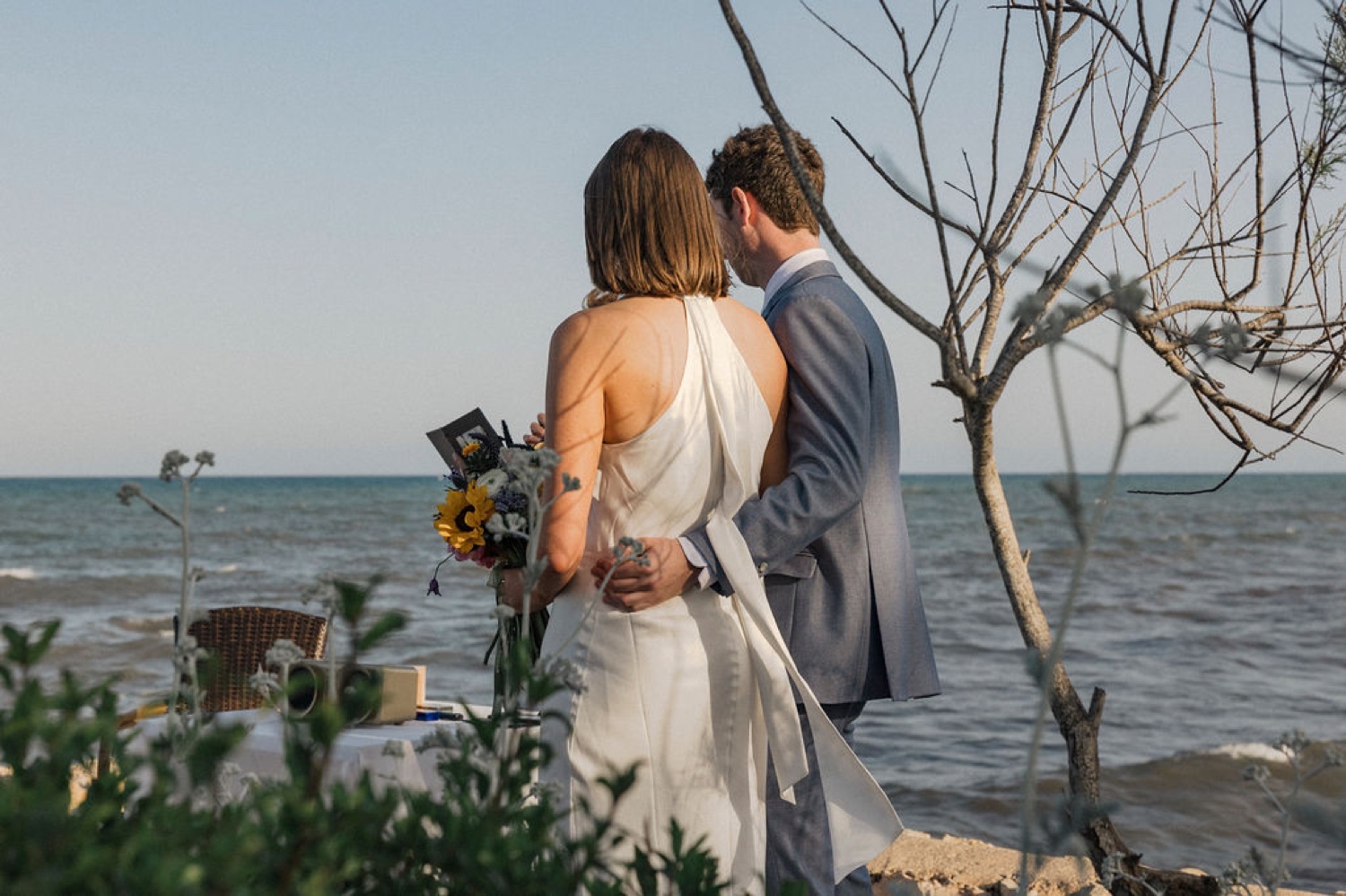 A couple embracing at the mirador of Restaurant Sa Punta in Mallorca, with the sea behind them